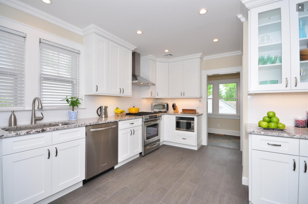 Open concept kitchen - mid-sized transitional u-shaped porcelain tile and gray floor open concept kitchen idea in Orlando with an undermount sink, shaker cabinets, white cabinets, granite countertops, white backsplash, ceramic backsplash, stainless steel appliances, no island and white countertops