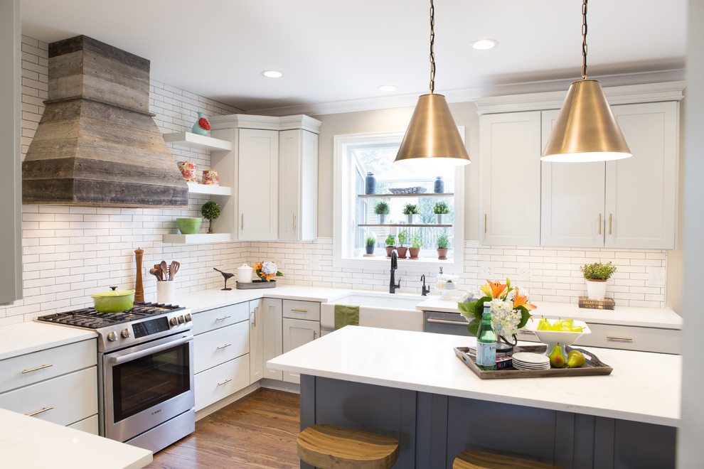 Mid-sized transitional u-shaped medium tone wood floor and brown floor eat-in kitchen photo in Chicago with a farmhouse sink, shaker cabinets, quartz countertops, white backsplash, subway tile backsplash, stainless steel appliances, an island and white countertops