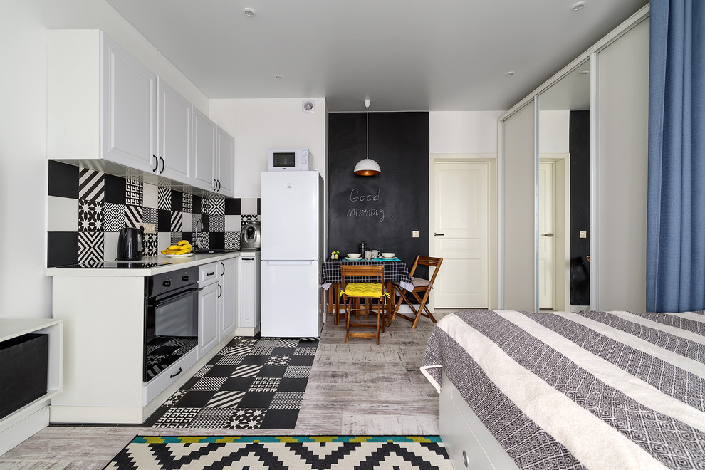 Design ideas for a scandinavian l-shaped open plan kitchen in Other with a drop-in sink, raised-panel cabinets, white cabinets, multi-coloured splashback, black appliances, no island, multi-coloured floor and white benchtop.