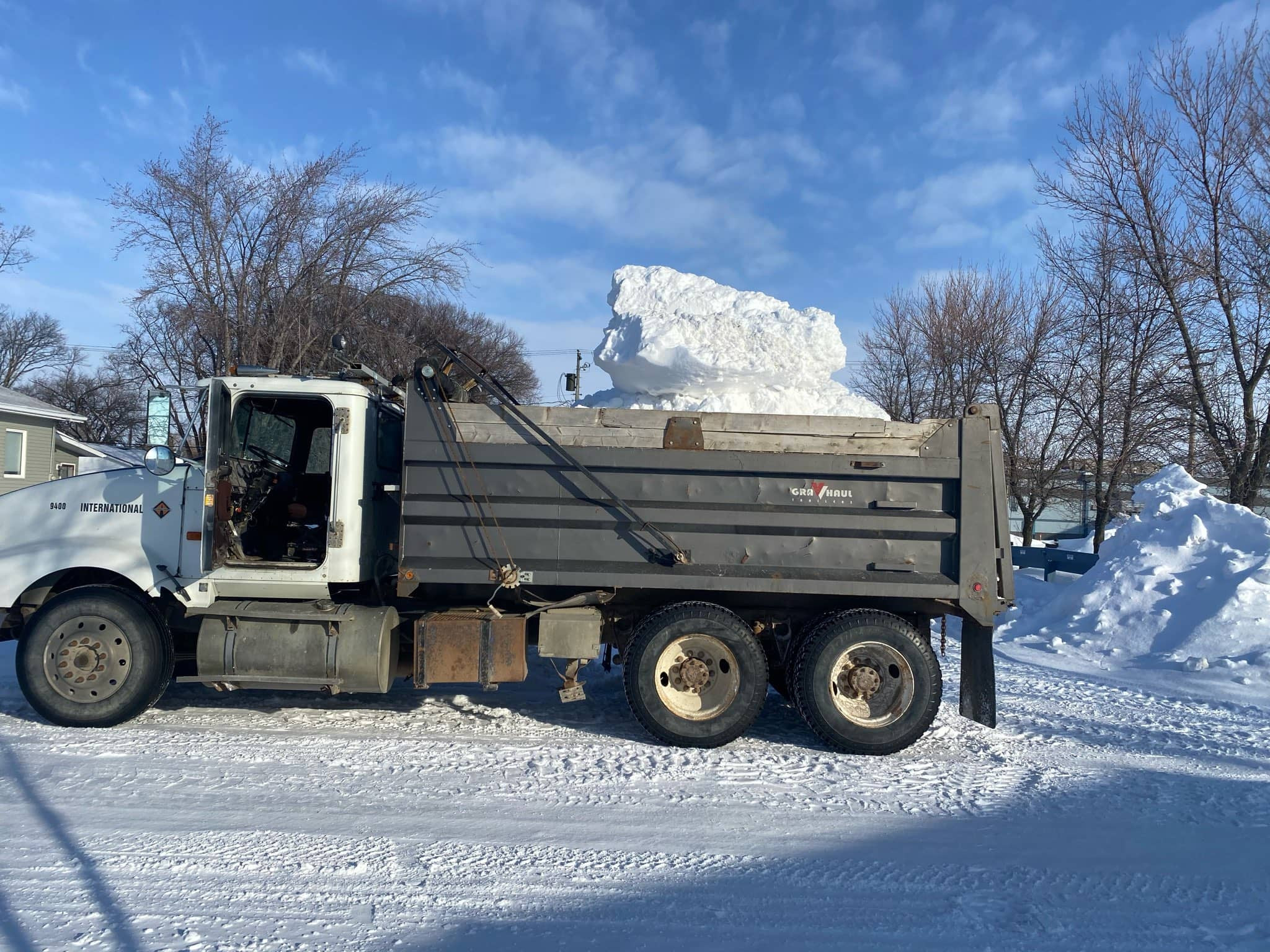 Tandem dump truck hauling large chunk of snow