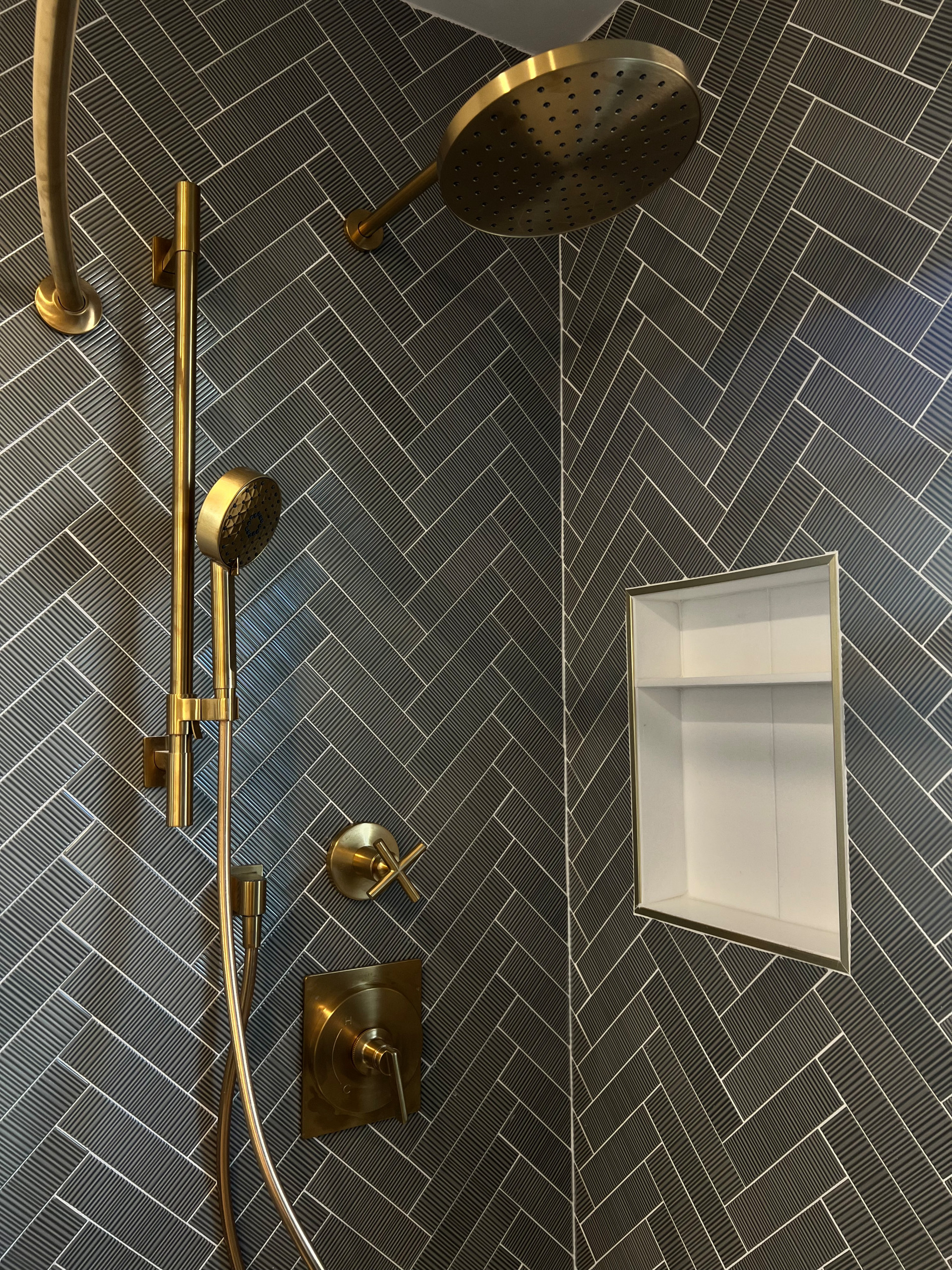 Transitional Primary Bathroom Renovation with herringbone ribbed tile, double vanity sink, and checkered flooring.