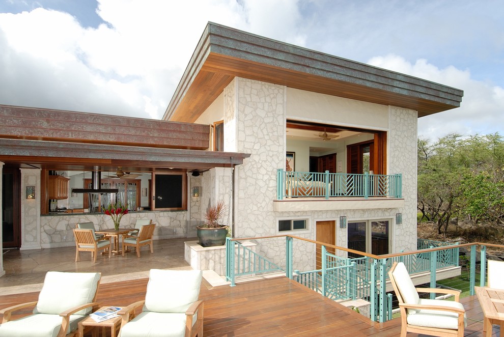 This is an example of a tropical two-storey exterior in Hawaii with stone veneer.