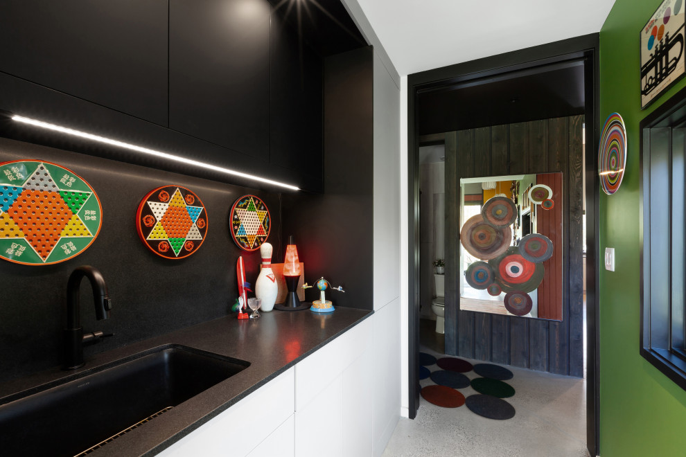 Idée de décoration pour un petit bureau minimaliste de type studio avec un mur vert, sol en béton ciré, un bureau intégré et un sol gris.
