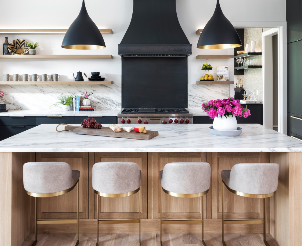 This is an example of a large contemporary kitchen in Minneapolis with flat-panel cabinets, black cabinets, marble benchtops, white splashback, marble splashback, stainless steel appliances, light hardwood floors, with island and white benchtop.