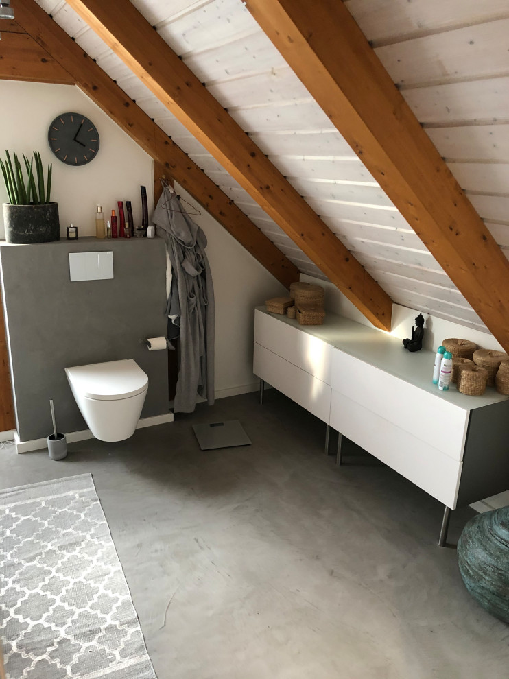 Duschbad With flächenbündigen Schrankfronten, grauen Schränken, bodengleicher Dusche, Wandtoilette mit Spülkasten, grauen Fliesen, Steinplatten, weißer Wandfarbe, Betonboden, Einbauwaschbecken, Glaswaschbecken/Glaswaschtisch, grauem Boden, Falttür-Duschabtrennung, weißer Waschtischplatte, Duschbank, Einzelwaschbecken, eingebautem Waschtisch, Holzdecke and Ziegelwänden in Cologne