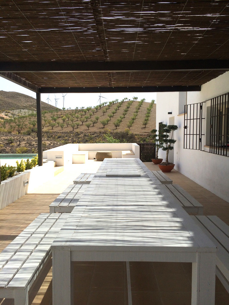 Diseño de terraza in patio lateral With suelo de baldosas and pérgola