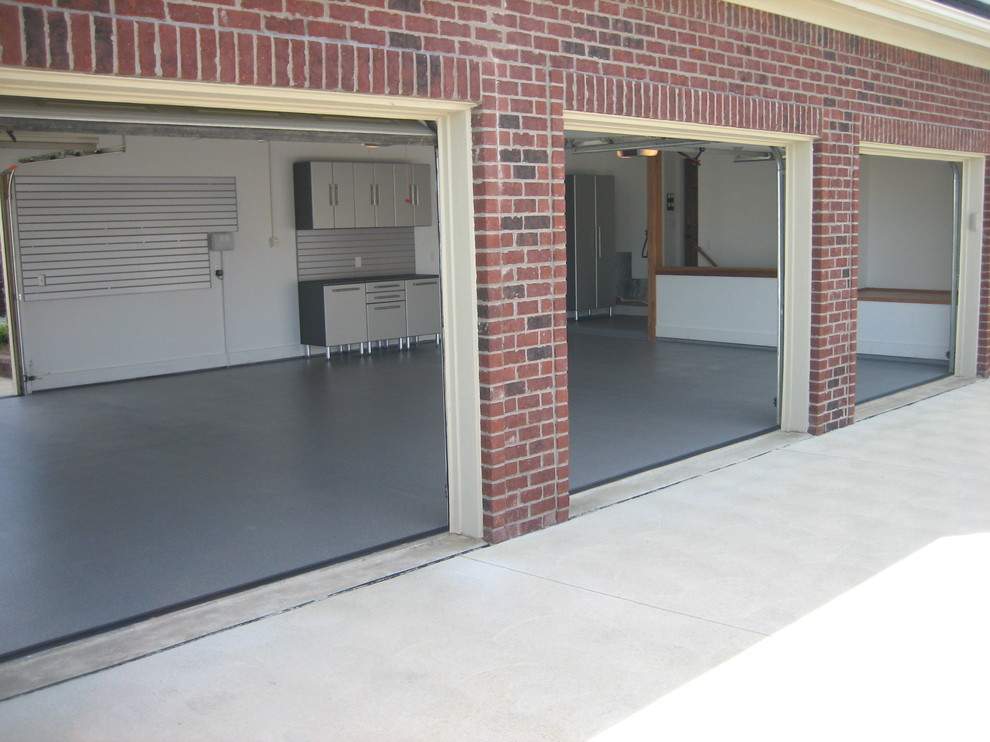 This is an example of a mid-sized traditional attached three-car garage in Other.
