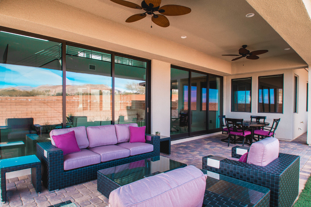 Large contemporary backyard patio in Las Vegas with an outdoor kitchen, brick pavers and an awning.