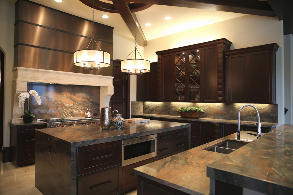 This is an example of a large transitional u-shaped eat-in kitchen in Dallas with dark wood cabinets, granite benchtops, black splashback, stone slab splashback, stainless steel appliances, travertine floors, with island, an undermount sink and shaker cabinets.