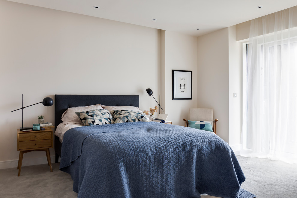 This is an example of a contemporary bedroom in London with beige walls, carpet, no fireplace and grey floor.