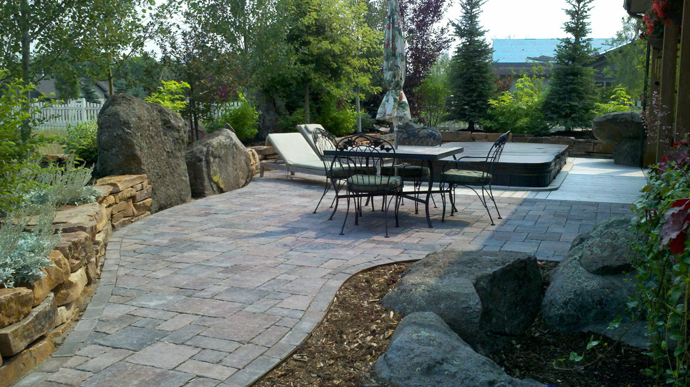 Mid-sized traditional backyard patio in Other with brick pavers and no cover.