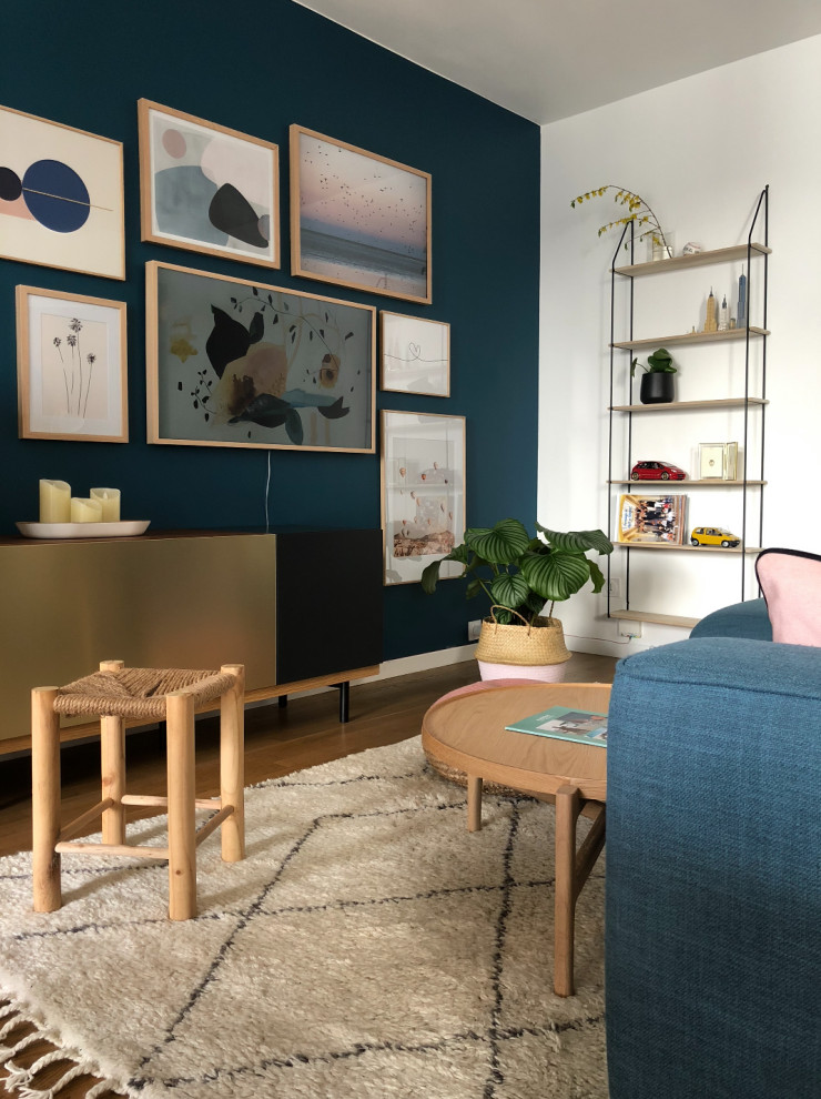 Design ideas for a small scandinavian open plan living room in Lyon with blue walls, light hardwood flooring, no fireplace, a wall mounted tv and brown floors.