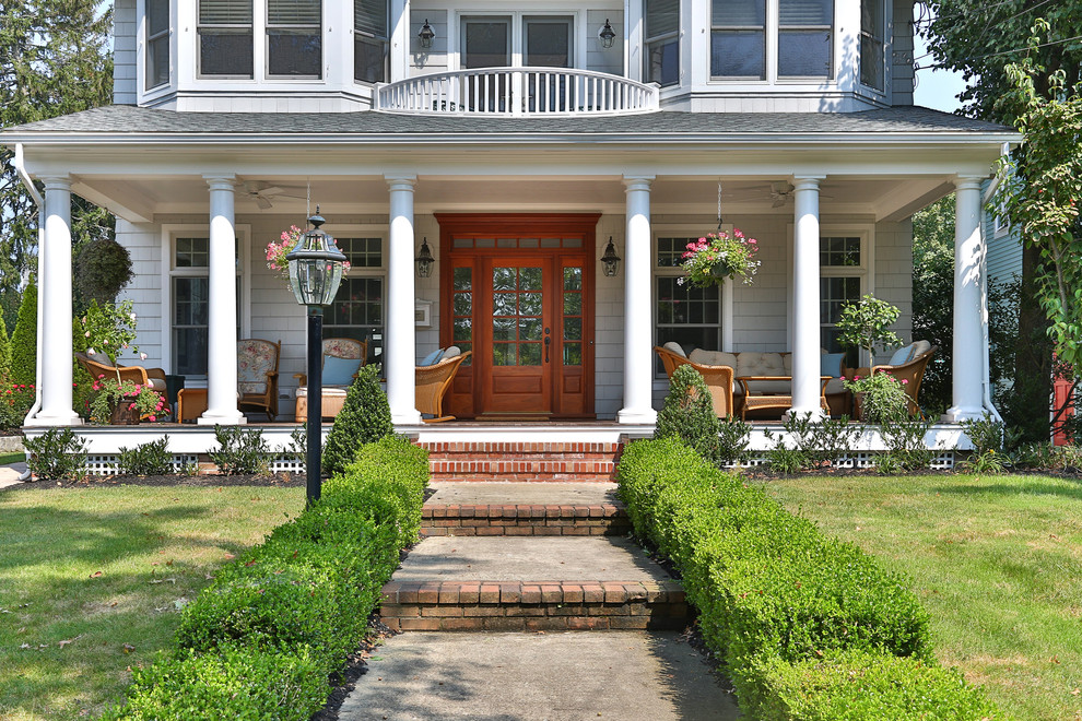 Inspiration for a traditional front yard verandah in New York with a roof extension.