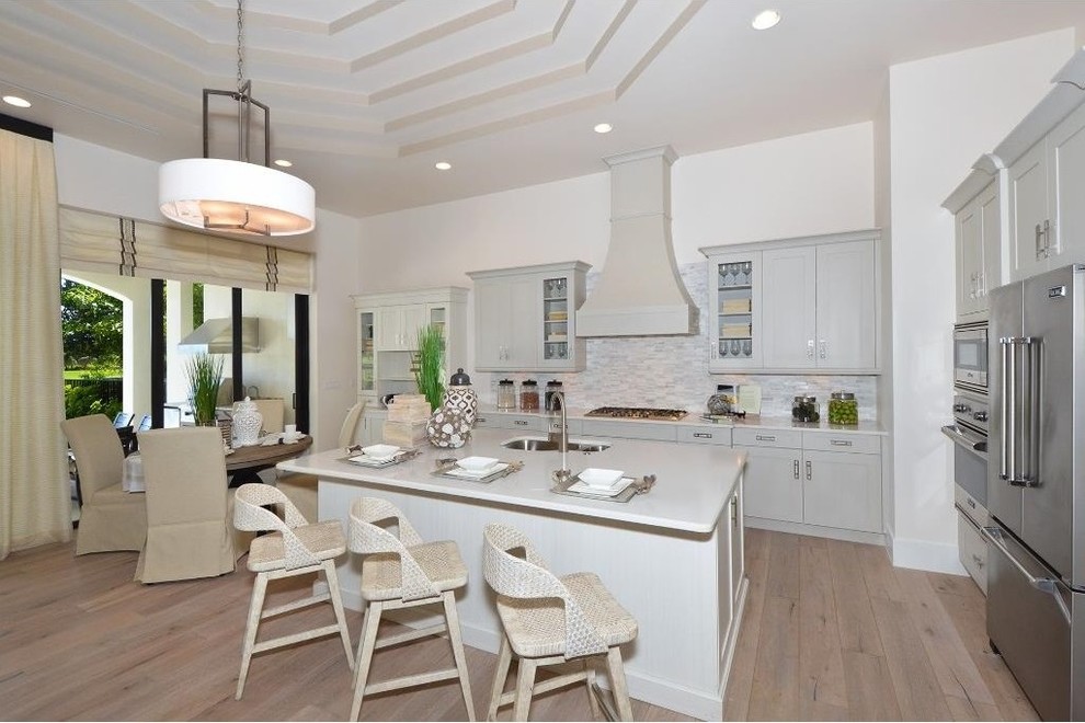 Eat-in kitchen - large transitional u-shaped light wood floor eat-in kitchen idea in Miami with a drop-in sink, flat-panel cabinets, gray cabinets, quartzite countertops, multicolored backsplash, stone tile backsplash, stainless steel appliances and an island
