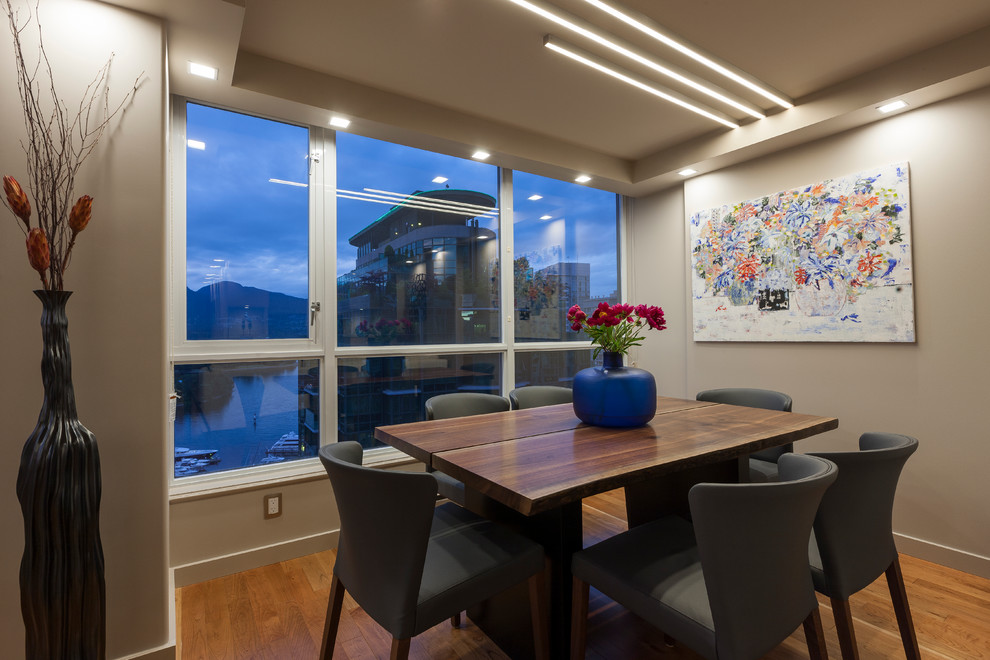 Mid-sized modern open plan dining in Vancouver with beige walls and medium hardwood floors.