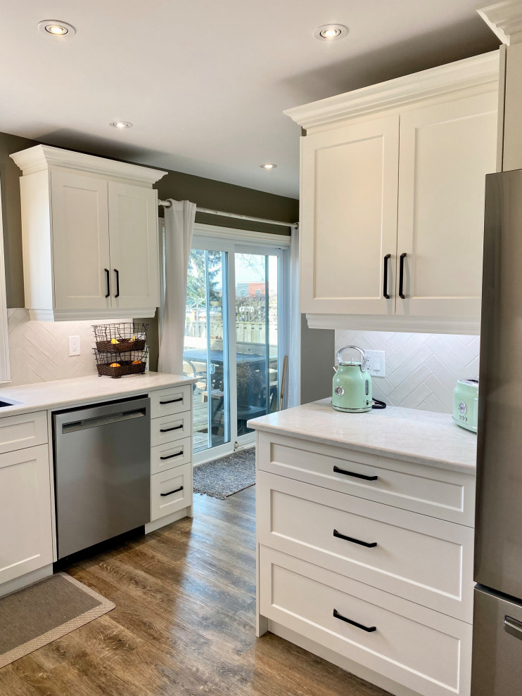 This is an example of a medium sized traditional l-shaped enclosed kitchen in Other with a double-bowl sink, recessed-panel cabinets, white cabinets, grey splashback, glass tiled splashback and no island.