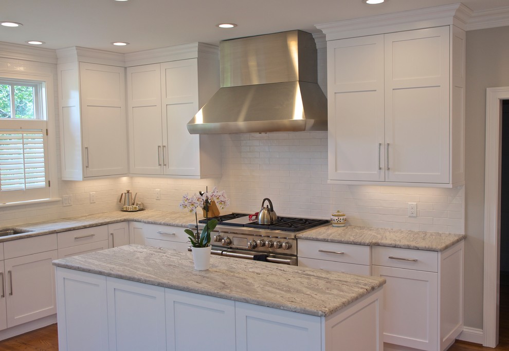 Inspiration for a large transitional l-shaped medium tone wood floor and brown floor eat-in kitchen remodel in Cincinnati with an undermount sink, shaker cabinets, white cabinets, granite countertops, white backsplash, ceramic backsplash, paneled appliances and an island
