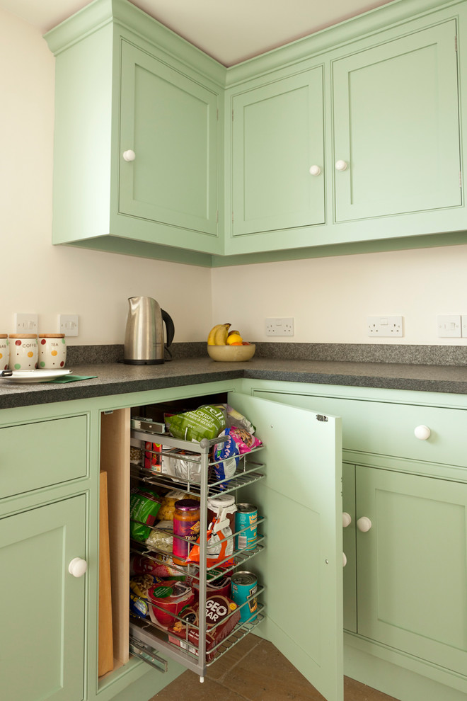 Inspiration for a large traditional l-shaped eat-in kitchen in Gloucestershire with a double-bowl sink, shaker cabinets, green cabinets, granite benchtops, metallic splashback, stainless steel appliances, travertine floors, no island, beige floor and black benchtop.