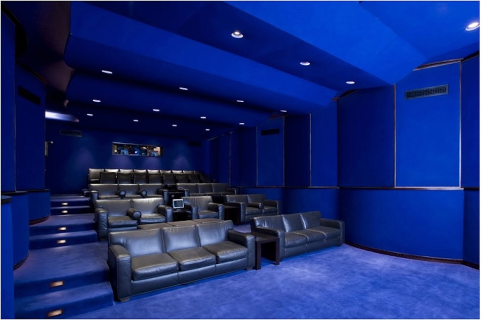 This is an example of a mid-sized contemporary enclosed home theatre in Los Angeles with blue walls, carpet, a projector screen and blue floor.
