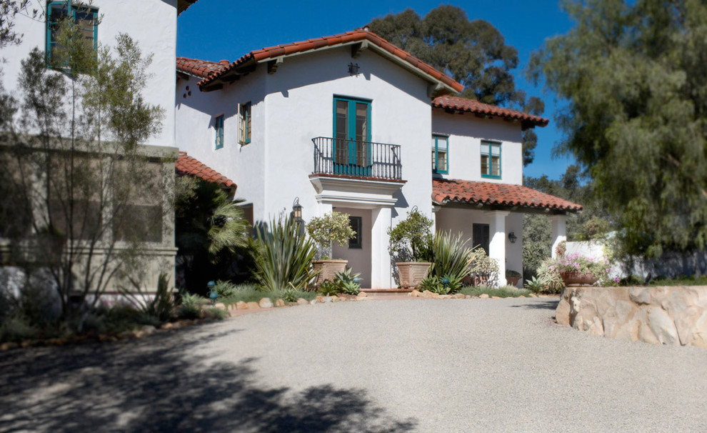 Large mediterranean two-storey stucco white house exterior in Santa Barbara with a hip roof and a tile roof.