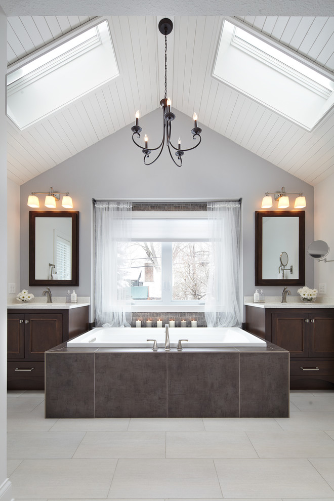Photo of a traditional master bathroom in Minneapolis with an undermount sink, dark wood cabinets, engineered quartz benchtops, a drop-in tub, shaker cabinets and grey walls.