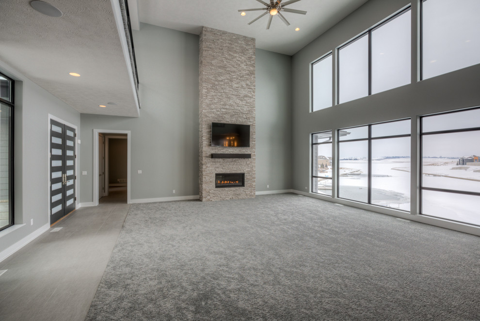 This is an example of a modern family room in Omaha with grey walls, a standard fireplace and a stone fireplace surround.