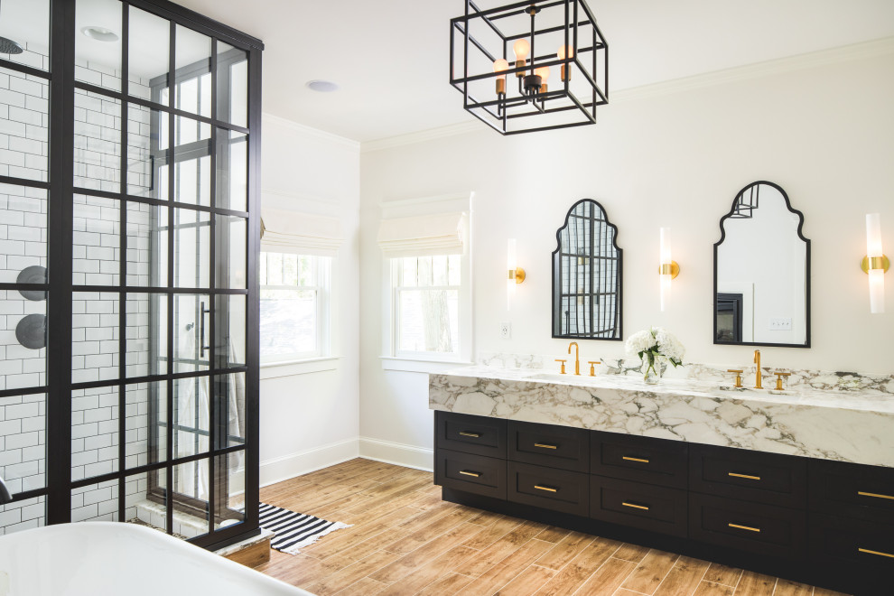 Design ideas for a mid-sized transitional master bathroom in Atlanta with shaker cabinets, black cabinets, a freestanding tub, a corner shower, quartzite benchtops, white walls, an undermount sink, brown floor and white benchtops.