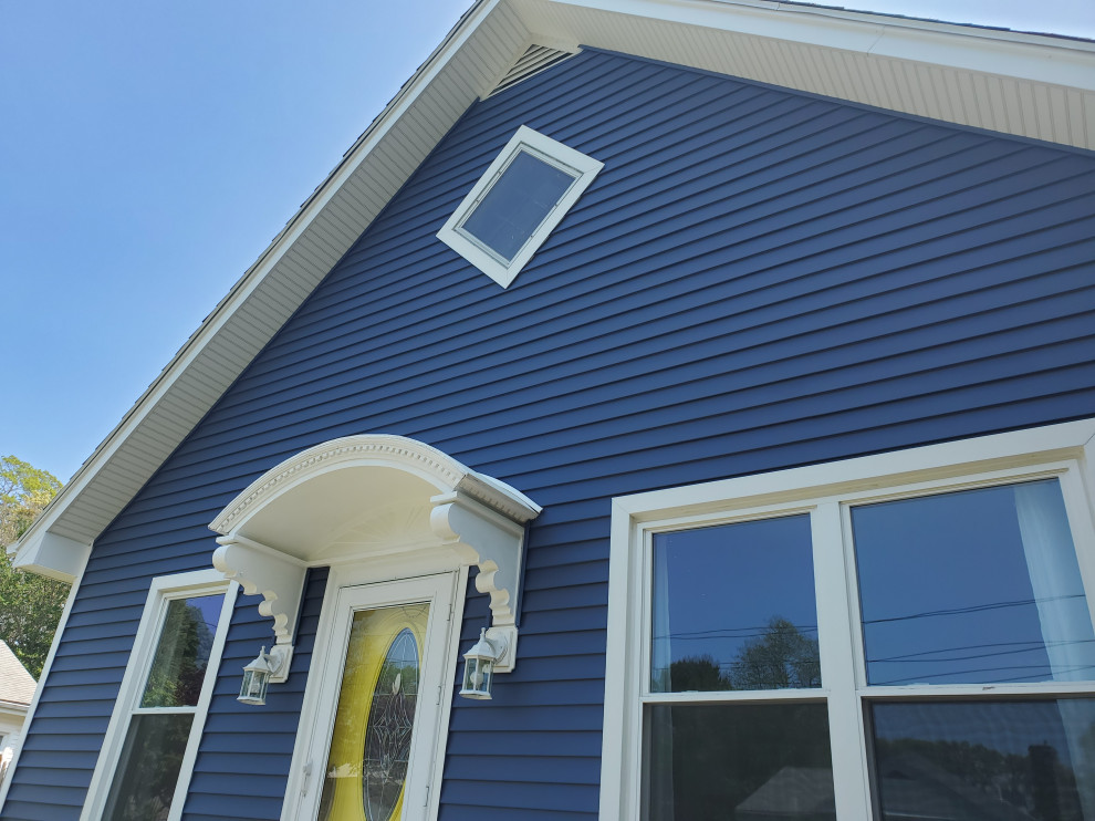 Traditional two-storey blue house exterior in Providence with vinyl siding, a gable roof, a shingle roof and clapboard siding.