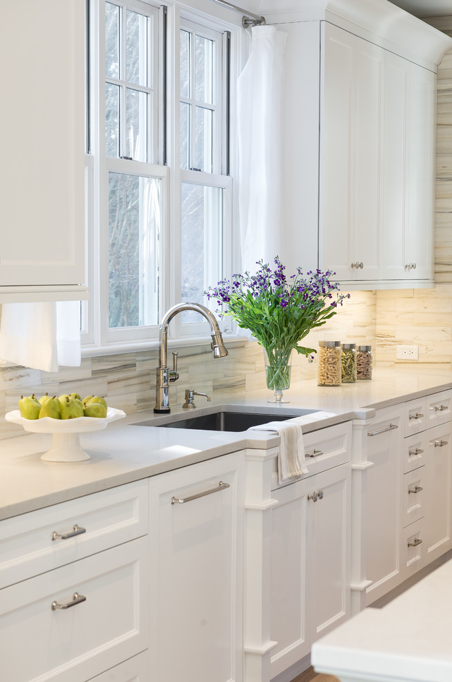 Inspiration for a mid-sized traditional u-shaped eat-in kitchen in New York with an undermount sink, recessed-panel cabinets, white cabinets, quartz benchtops, white splashback, subway tile splashback, stainless steel appliances, light hardwood floors and with island.