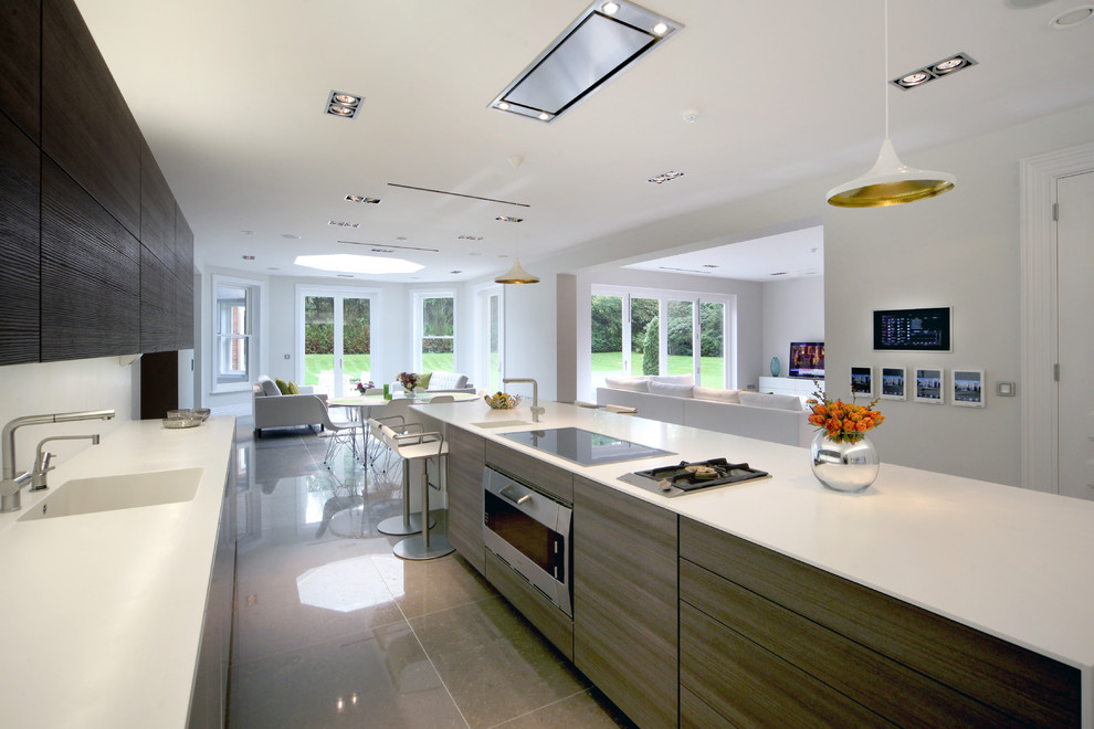 Photo of a contemporary galley open plan kitchen in Other with an integrated sink, flat-panel cabinets, dark wood cabinets, white splashback, stainless steel appliances and with island.