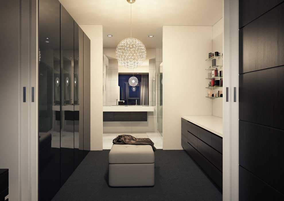 Photo of a large modern gender-neutral walk-in wardrobe in Melbourne with flat-panel cabinets, dark wood cabinets and carpet.