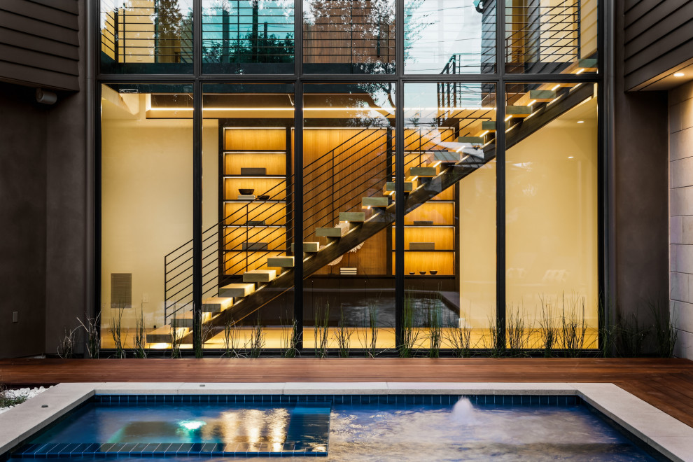 Cette photo montre une grande piscine hors-sol et arrière tendance rectangle avec un bain bouillonnant et une terrasse en bois.