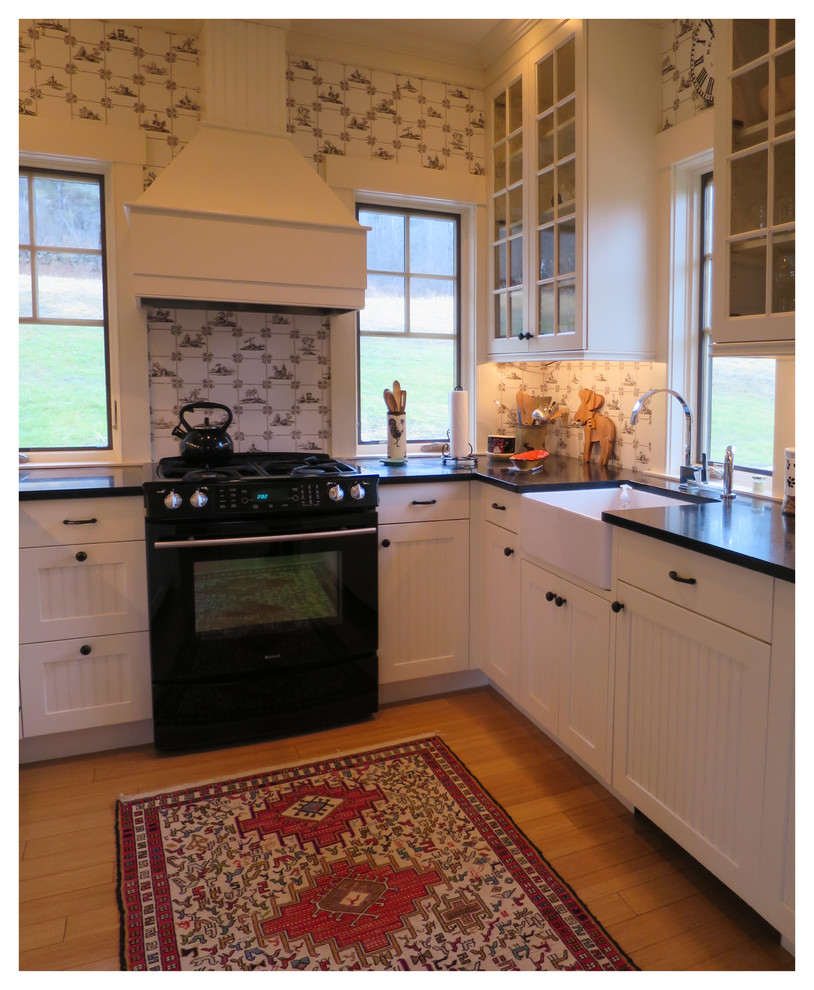 Design ideas for a small country u-shaped separate kitchen in Boston with a farmhouse sink, beaded inset cabinets, beige cabinets, granite benchtops, black appliances, bamboo floors and no island.