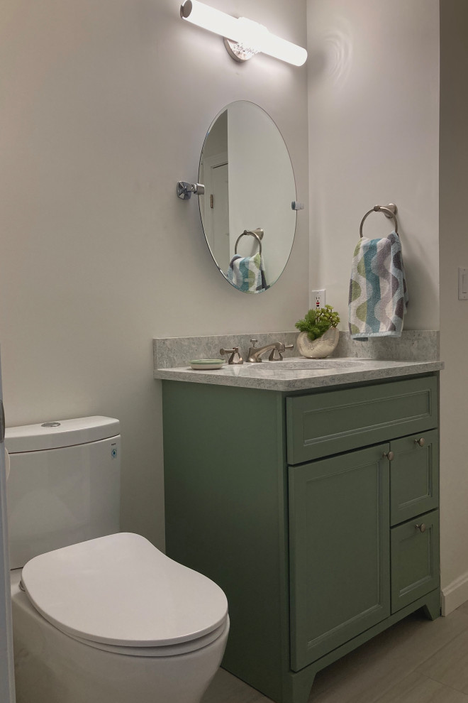 Cette photo montre une petite salle de bain bord de mer avec un placard à porte shaker, des portes de placard blanches, un sol en carrelage de porcelaine, un lavabo encastré, un plan de toilette en quartz modifié, une cabine de douche à porte battante, un plan de toilette bleu, meuble simple vasque, WC séparés, un carrelage métro, un mur gris, un sol gris, meuble-lavabo sur pied et un carrelage vert.