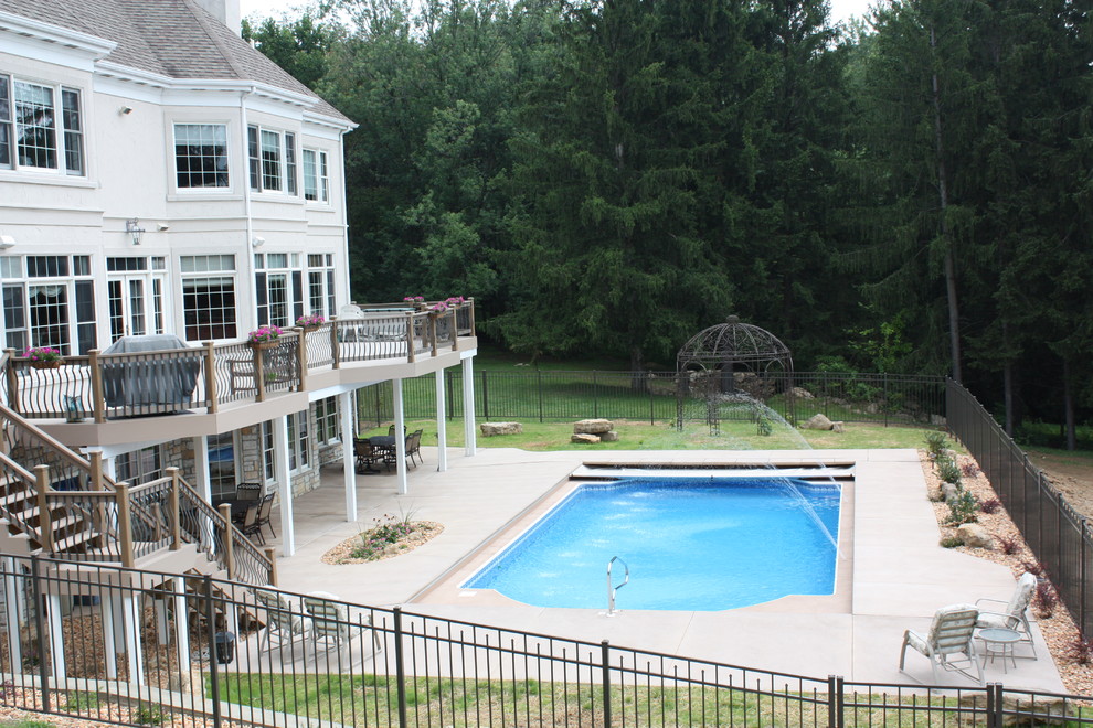 Example of a large transitional backyard concrete and custom-shaped lap pool design