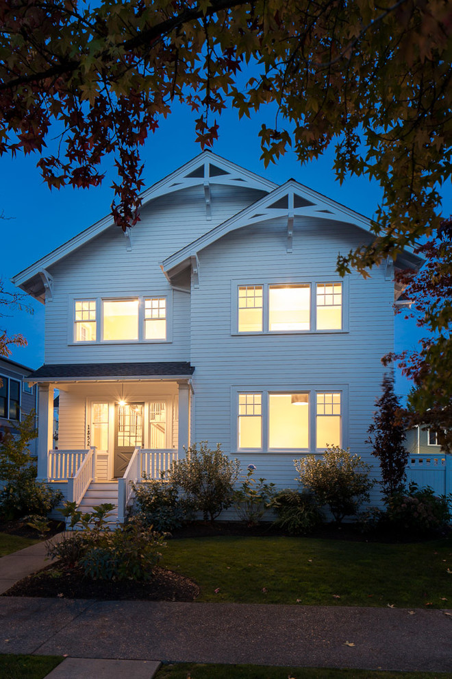 Photo of a large traditional three-storey white exterior in Seattle with wood siding.