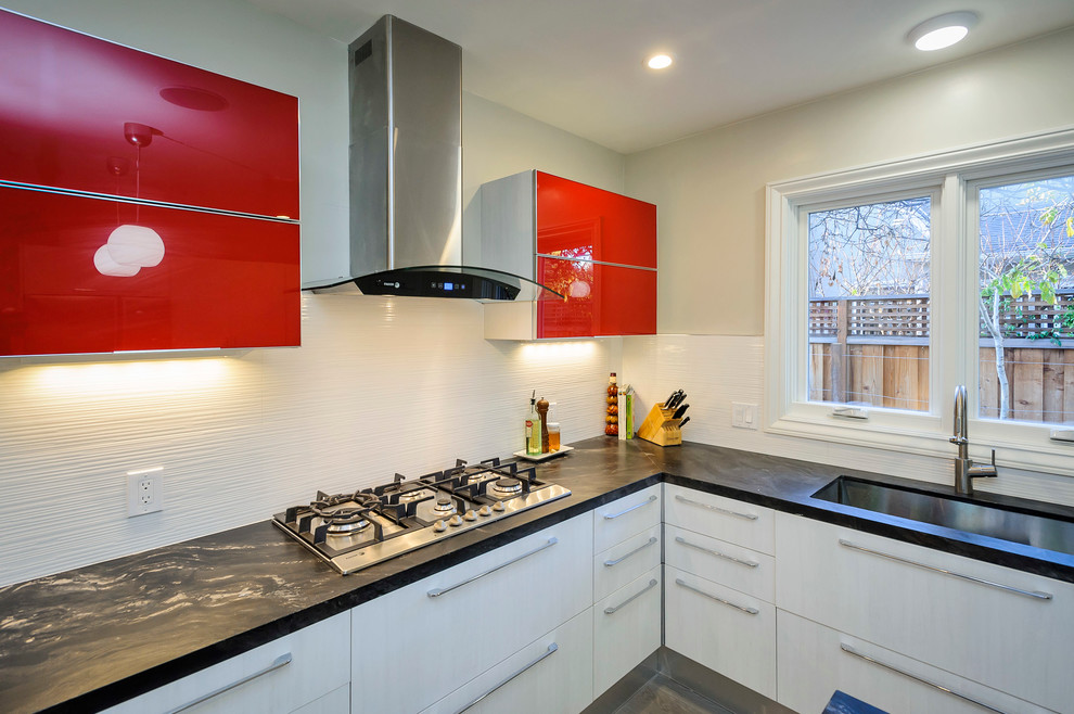 This is an example of a contemporary u-shaped eat-in kitchen in San Francisco with an undermount sink, white cabinets, granite benchtops, white splashback, ceramic splashback and stainless steel appliances.