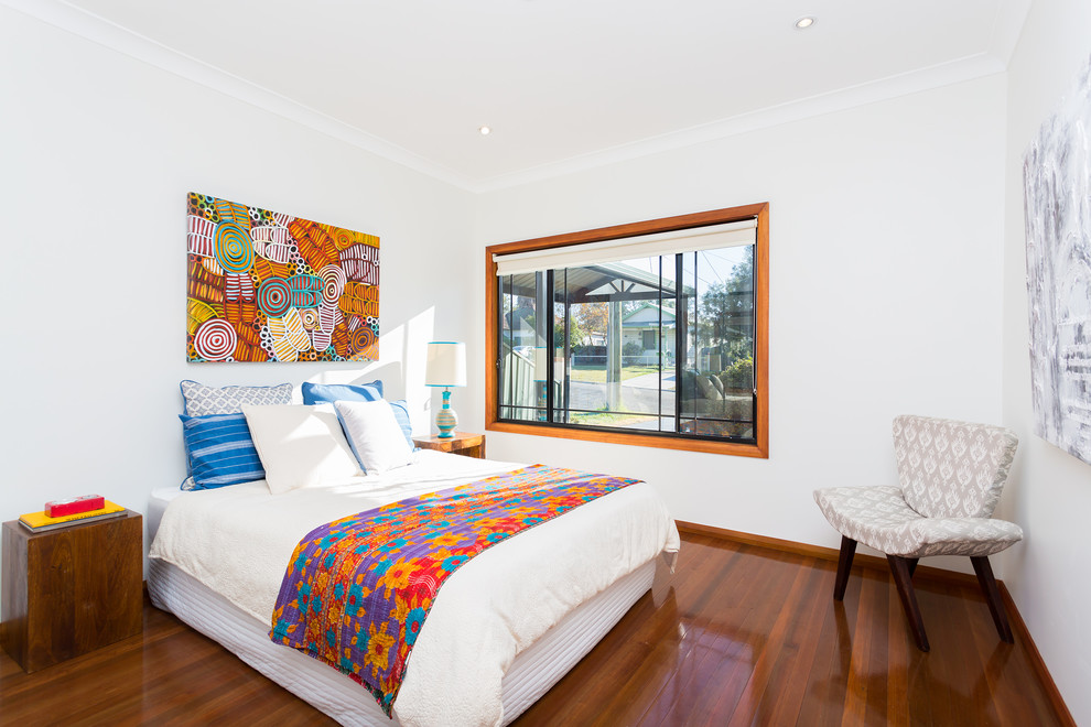Small eclectic guest bedroom in Sydney with white walls, dark hardwood floors and brown floor.