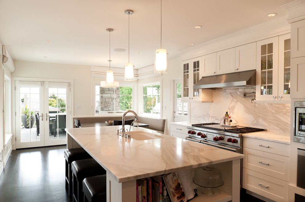This is an example of a transitional eat-in kitchen in Seattle with shaker cabinets, marble benchtops, an undermount sink, white splashback, stainless steel appliances, dark hardwood floors and marble splashback.