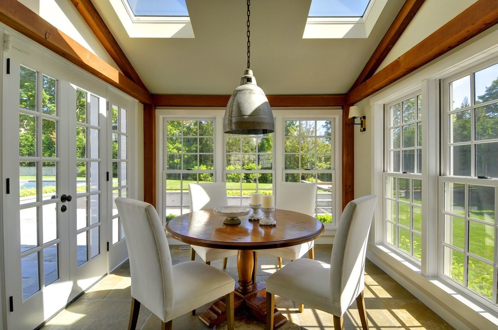 This is an example of a mid-sized traditional sunroom in New York with limestone floors, no fireplace and a skylight.