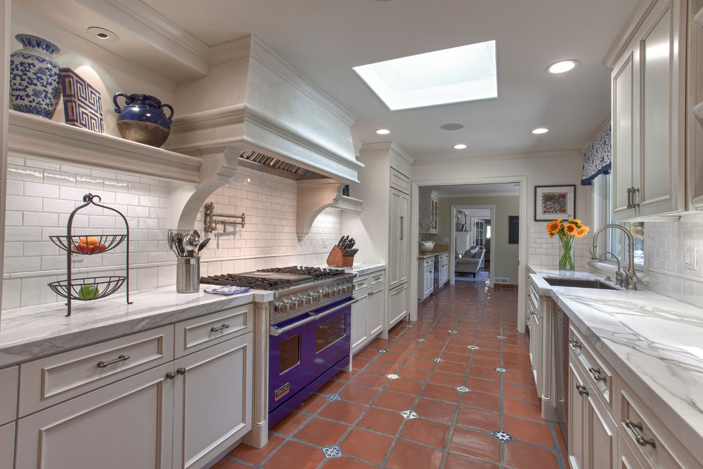 Photo of a traditional galley separate kitchen in San Francisco with recessed-panel cabinets, grey cabinets, marble benchtops, white splashback, subway tile splashback and coloured appliances.