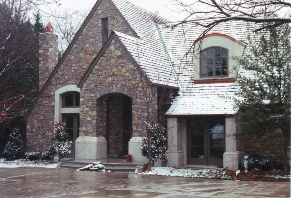 Inspiration for a mid-sized traditional two-storey beige exterior in Oklahoma City with stone veneer and a gable roof.