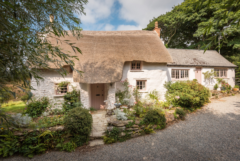 This is an example of a mid-sized traditional two-storey pink house exterior in Cornwall with a gable roof.
