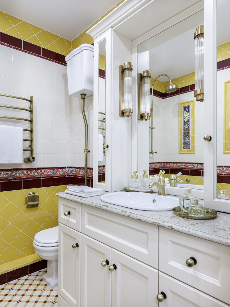 Inspiration pour une salle de bain principale traditionnelle de taille moyenne avec un placard avec porte à panneau encastré, des portes de placard beiges, une baignoire d'angle, un combiné douche/baignoire, un carrelage jaune, des carreaux de céramique, un mur beige, un sol en carrelage de porcelaine, un lavabo posé, un plan de toilette en quartz modifié, un sol multicolore, aucune cabine, un plan de toilette beige, des toilettes cachées, meuble simple vasque et meuble-lavabo sur pied.