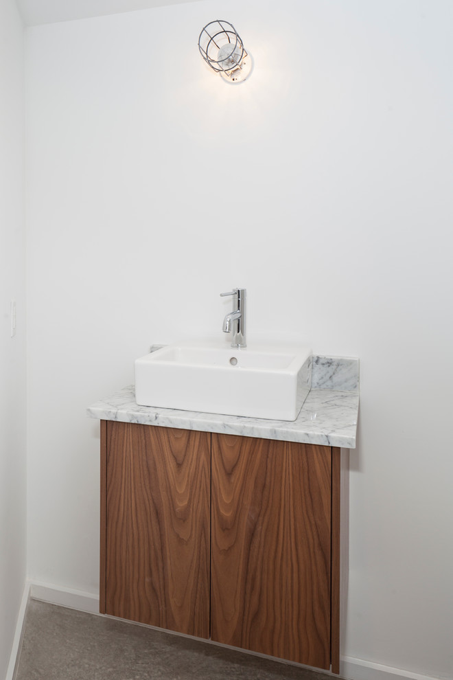 Idéer för att renovera ett litet funkis grå grått badrum, med släta luckor, skåp i mörkt trä, en toalettstol med hel cisternkåpa, vit kakel, vita väggar, betonggolv, ett fristående handfat, marmorbänkskiva och grått golv
