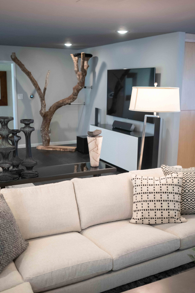 Immagine di un grande soggiorno minimalista aperto con pavimento in vinile, pavimento nero, pareti grigie, camino classico e cornice del camino in pietra