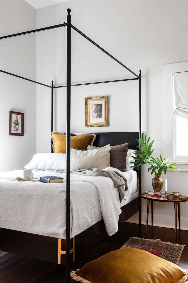 This is an example of a transitional guest bedroom in New Orleans with white walls, dark hardwood floors and brown floor.