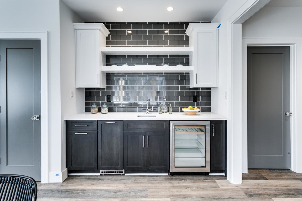 Inspiration for a country single-wall wet bar in DC Metro with an undermount sink, shaker cabinets, white cabinets, quartz benchtops, black splashback, subway tile splashback and vinyl floors.