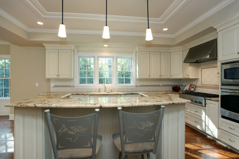 Inspiration for a farmhouse l-shaped medium tone wood floor eat-in kitchen remodel in New York with an undermount sink, raised-panel cabinets, white cabinets, white backsplash, ceramic backsplash, stainless steel appliances and white walls