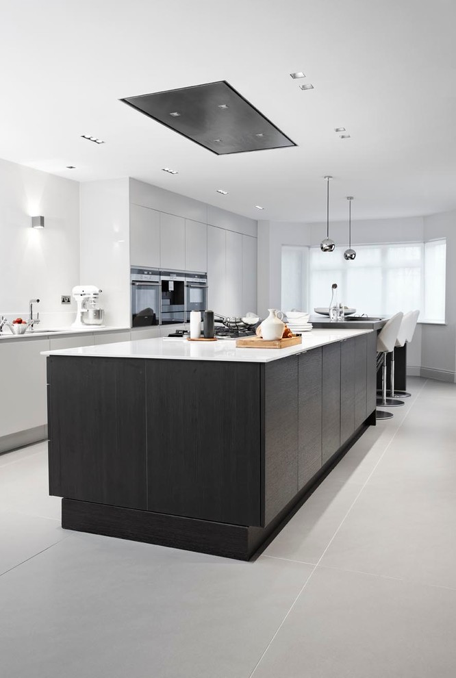 This is an example of a contemporary eat-in kitchen in London with flat-panel cabinets and black cabinets.